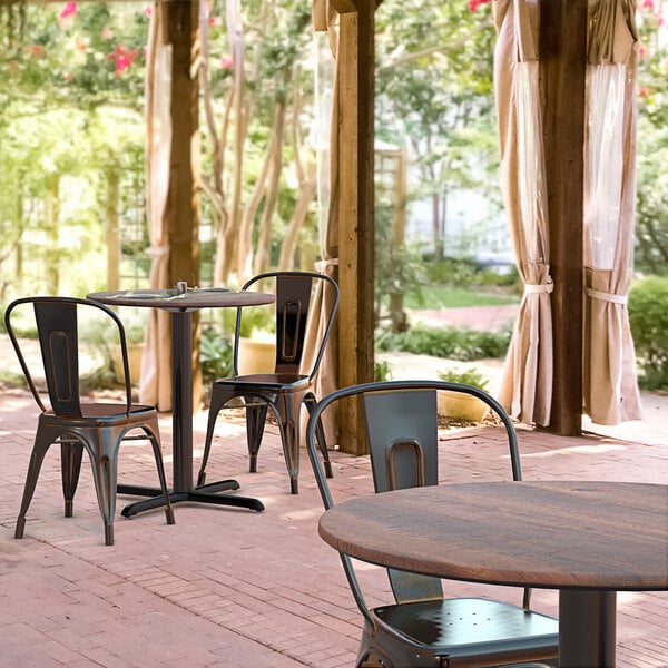 A Lancaster Table & Seating Excalibur table and chairs on an outdoor patio.