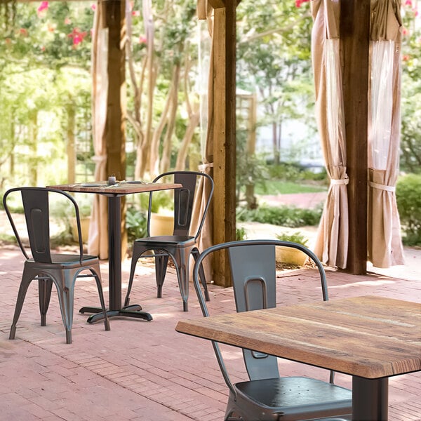 A Lancaster Table & Seating dining table and chairs on an outdoor patio.