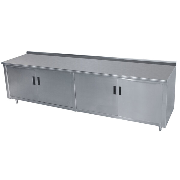 A stainless steel enclosed base work table with hinged doors and a backsplash.