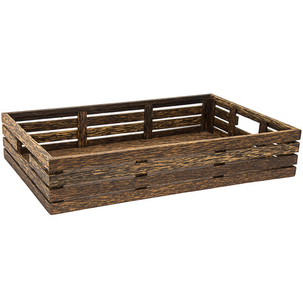 A rectangular palm wood basket with handles on a table in a salad bar.