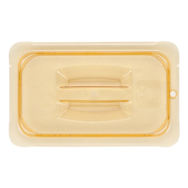 A Carlisle amber plastic lid with handles for a food container.