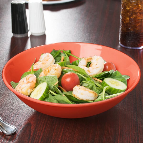 A bowl of salad with shrimp and vegetables in a GET Diamond Rio Orange melamine bowl.