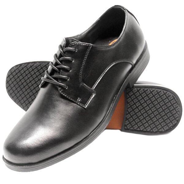 A pair of black leather Genuine Grip men's oxford shoes with rubber soles.