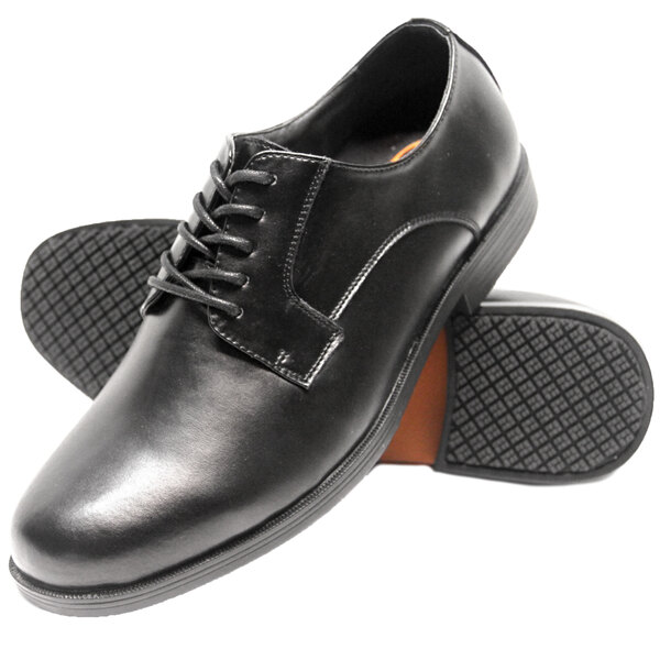 A pair of men's black leather Genuine Grip oxford shoes with rubber soles.