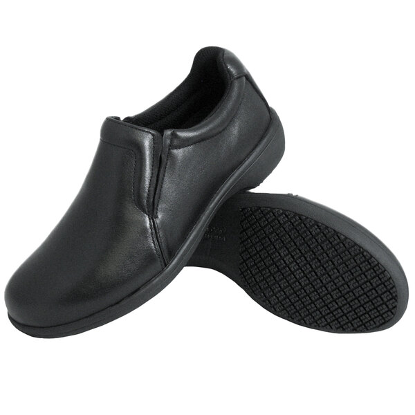 A pair of Genuine Grip black leather slip-on shoes with black soles.