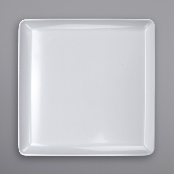 A white square plate on a white surface.
