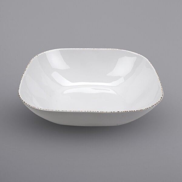 A white square bowl with gold trim.