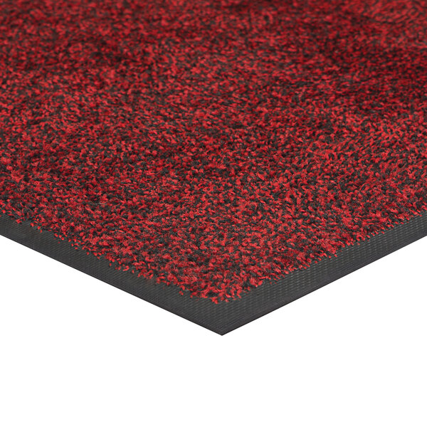 A white rectangular carpet mat with red and black spots.