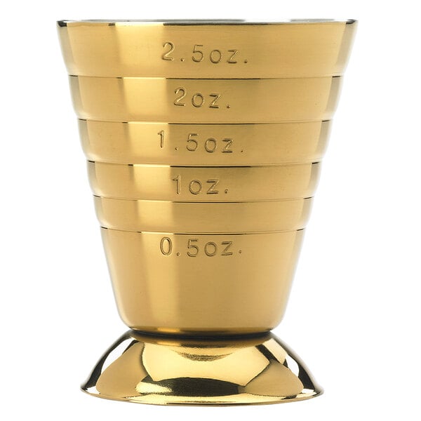 A gold-plated Barfly measuring jigger with measurements on it.