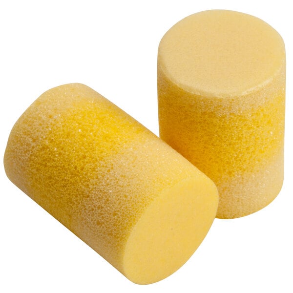 A close up of a pair of yellow foam 3M E-A-R Classic earplugs.