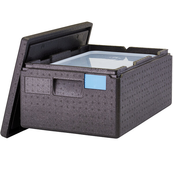 A black plastic Cambro Cam GoBox food pan carrier with a blue seal cover on a table.