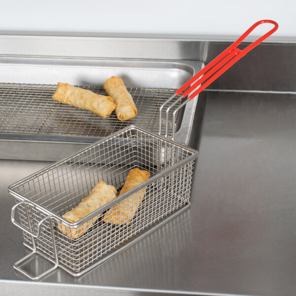 A Grindmaster fryer basket with food in it on a counter.