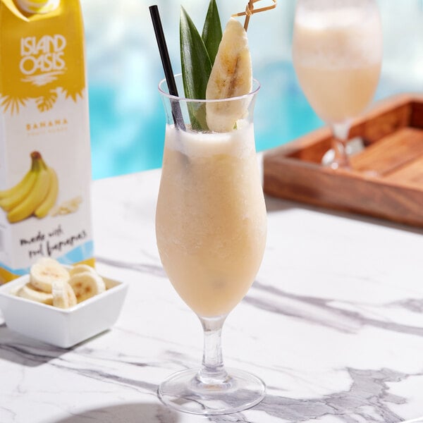 A glass of Island Oasis banana smoothie on a table.