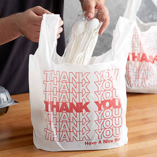 A man holding a white plastic bag with red "Thank You" text.