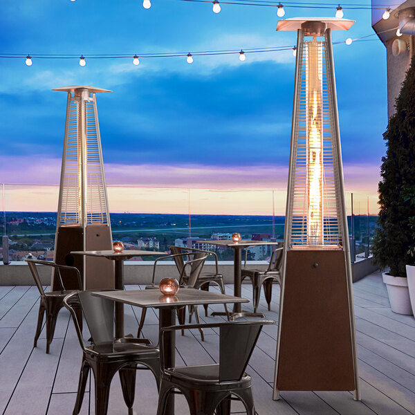 A patio with a Backyard Pro bronze portable patio heater with a glass tube over a table and chairs.