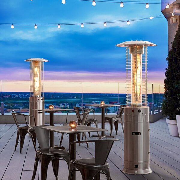 A Backyard Pro stainless steel round patio heater on a table on an outdoor patio.