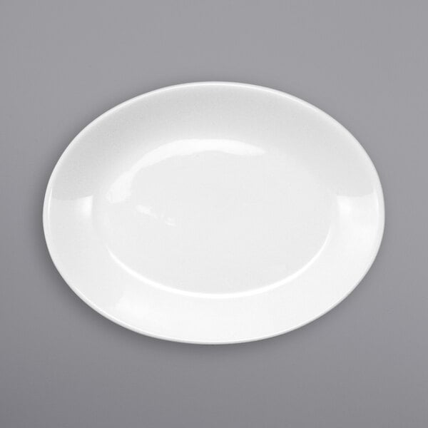 An International Tableware Torino oval porcelain platter with a white rim on a gray surface.