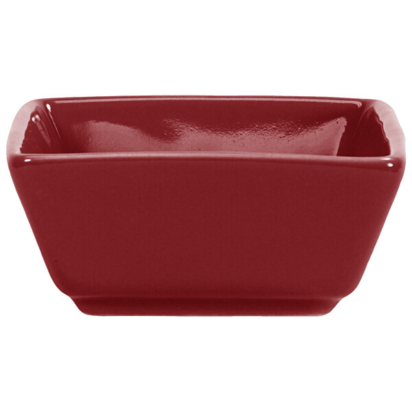 A red square porcelain ramekin with a white background.