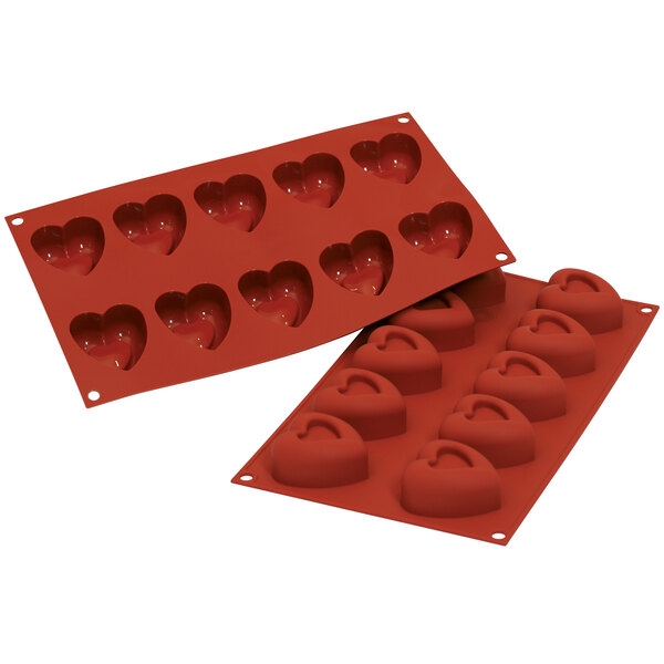 A red Silikomart silicone baking mold with heart-shaped cavities.