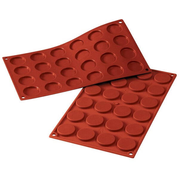 Two red Silikomart silicone baking molds with 24 mini Florentine cavities.