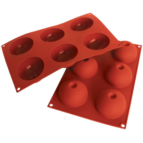 A red Silikomart silicone baking mold with six dome-shaped cavities.