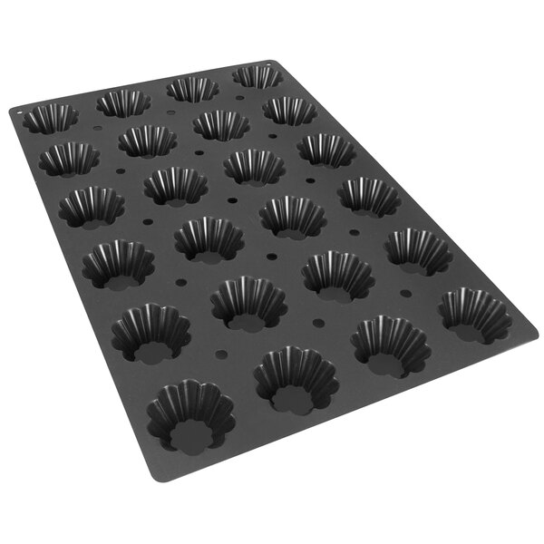 A black metal Silikomart baking mold with 24 scallop shaped cavities.