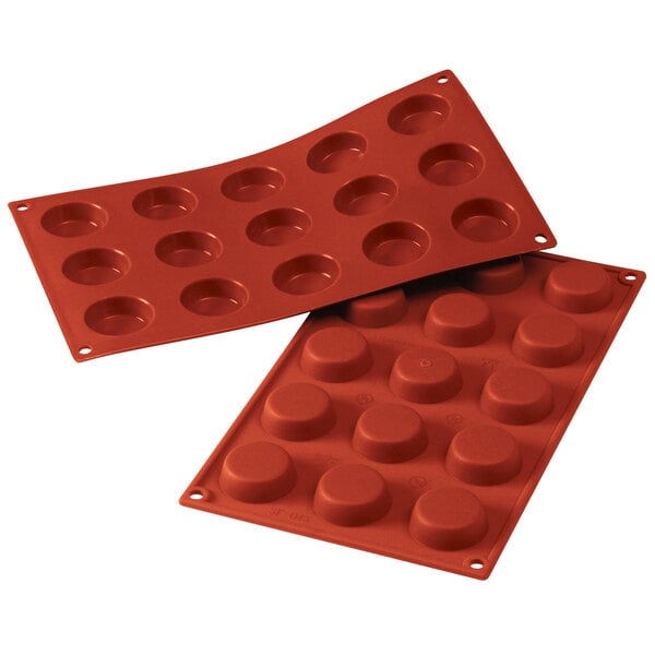 A red Silikomart silicone baking mold with 15 flan cavities.