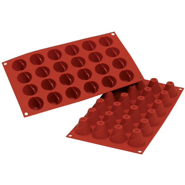 A close-up of a red Silikomart silicone baking mold with small cone-shaped cavities.