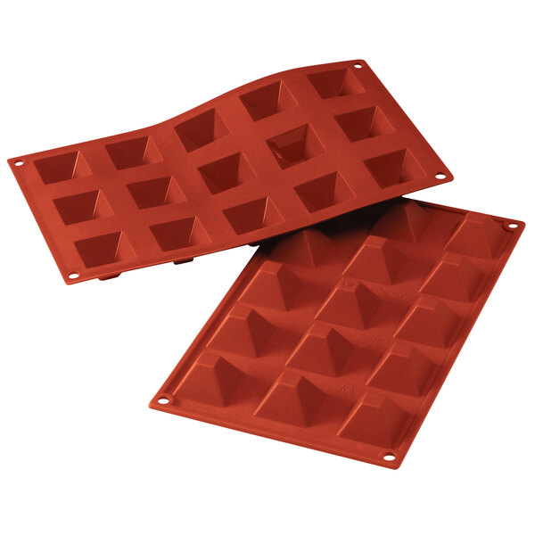 A red Silikomart silicone baking mold with pyramid-shaped cavities.