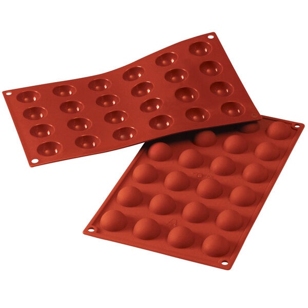 A red Silikomart silicone baking mold with 24 half sphere cavities and holes.