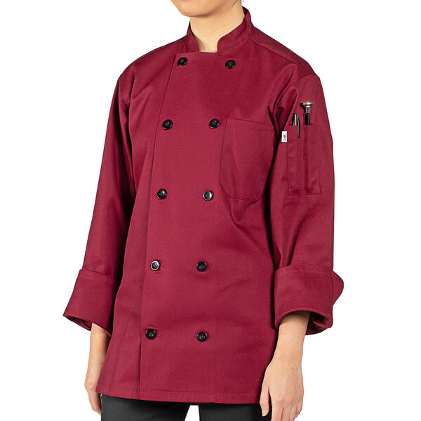 A person wearing a Uncommon Chef Moroccan burgundy long sleeve chef coat.
