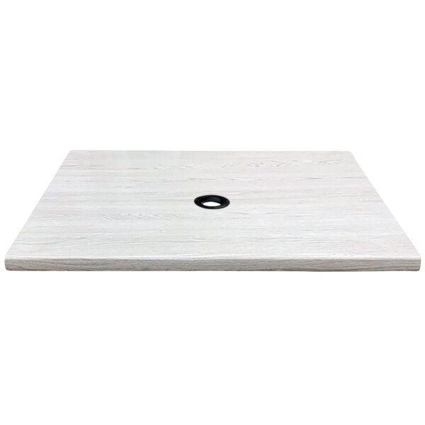 A white wood square with a black circle in the middle.