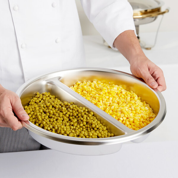 A chef holding a bowl of corn and peas.