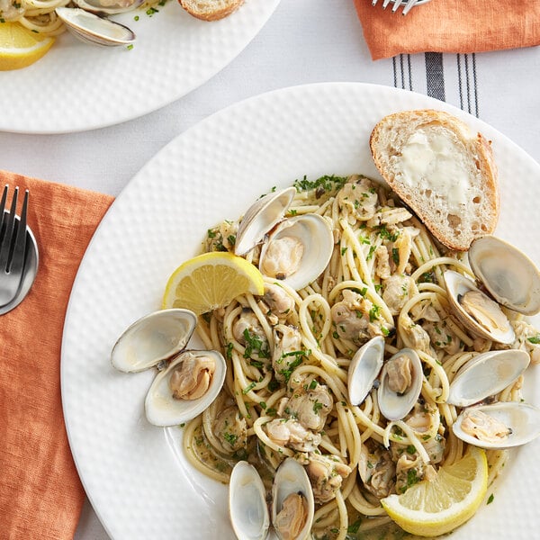 A plate of pasta with Rappahannock Oyster Co. Olde Salt Littleneck Clams and lemon slices.