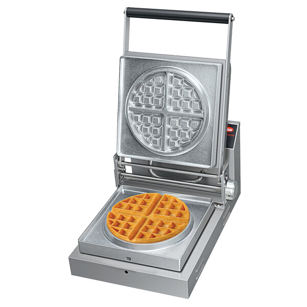 A Hatco commercial waffle maker with a round waffle in it.