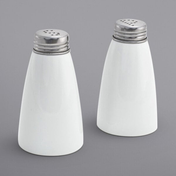Two white porcelain salt and pepper shakers.