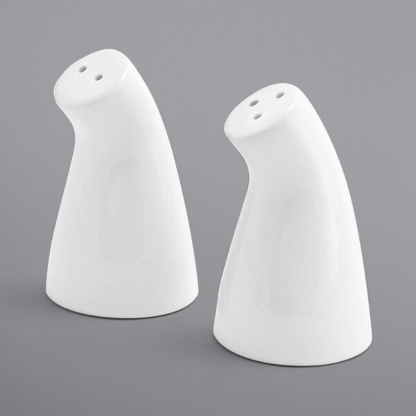 Two white ceramic Front of the House salt and pepper shakers on a gray surface.