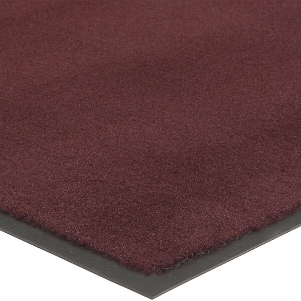A burgundy carpet mat with black border.