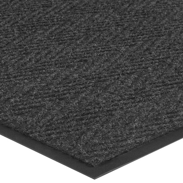 A Lavex charcoal indoor entrance mat with a black border and chevron pattern.