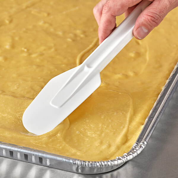 A person using a Linden Sweden white spatula to spread a cake.