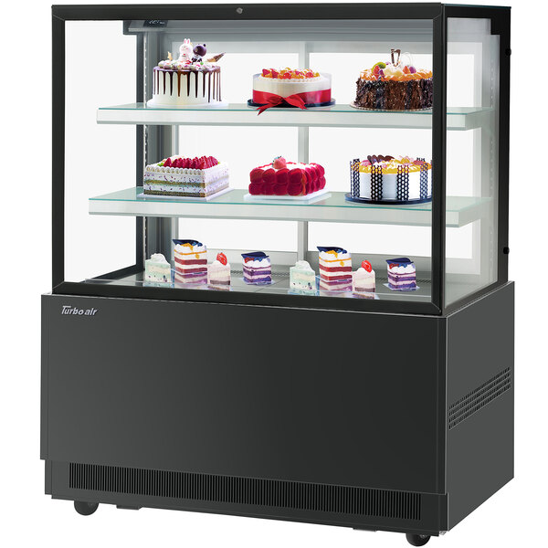 A Turbo-Air black refrigerated bakery display case filled with cakes.