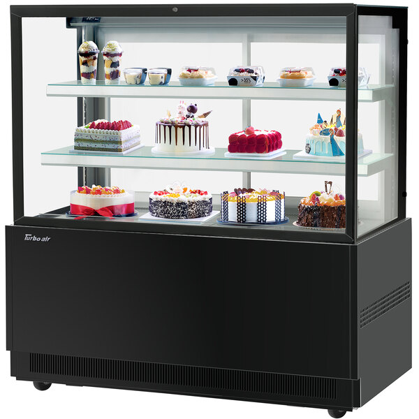A Turbo-Air black refrigerated bakery display case with cakes on shelves.