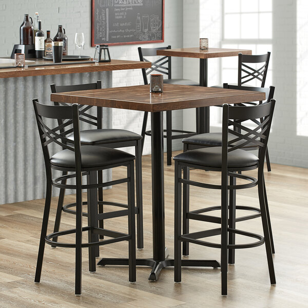 A Lancaster Table & Seating bar table with chairs around it.