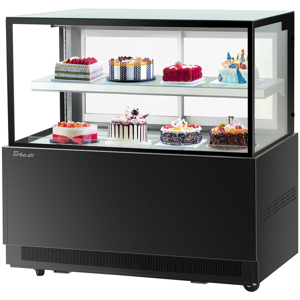 A Turbo-Air black refrigerated bakery display case with cakes on two tiers.