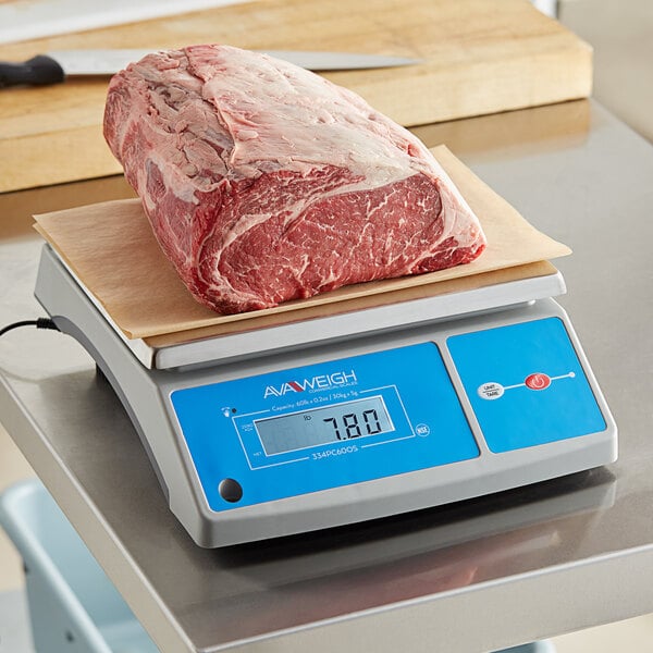 An AvaWeigh digital portion scale on a counter with a piece of raw meat on it.