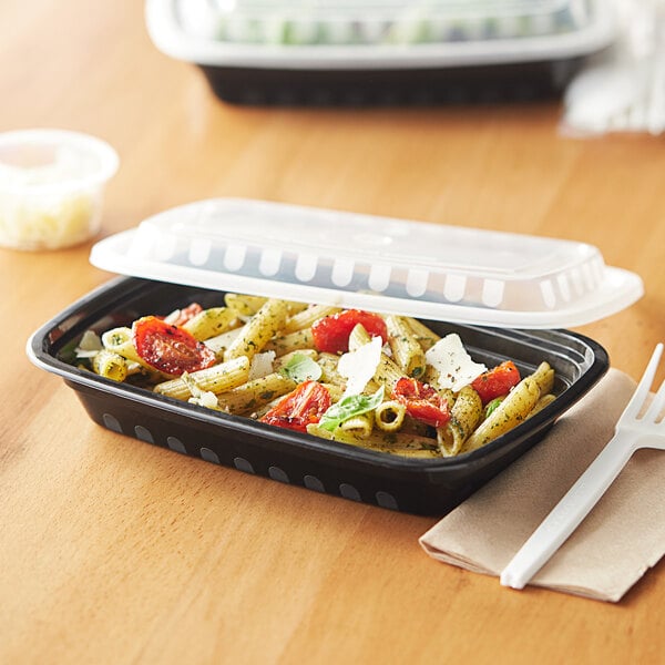 A Choice rectangular black plastic container of food with a white lid. A white plastic fork is next to the container.