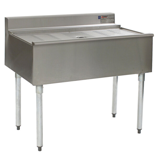 A stainless steel Eagle Group workstation with a drain on top.