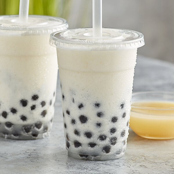 Two plastic cups of bubble tea with Bossen Yogurt Concentrated Syrup, black balls, and straws.