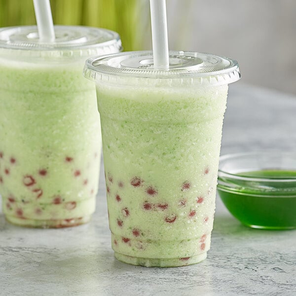 Two cups of Bossen Kiwi green smoothies with straws.