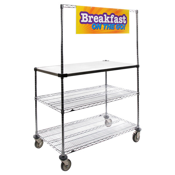 A Metro stainless steel workstation and serving cart with a "Breakfast On the Go" sign on it.